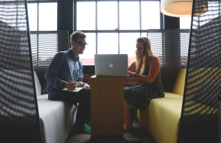 Two people working on a laptop