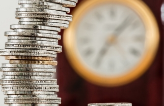 Coins stacked up against a clock