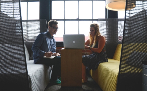 Two people working on a laptop
