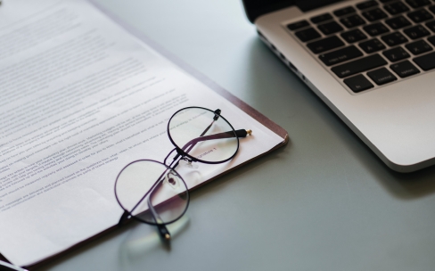 Glasses and a laptop on a desk
