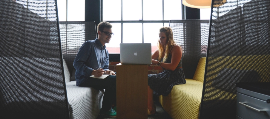 Two people working on a laptop