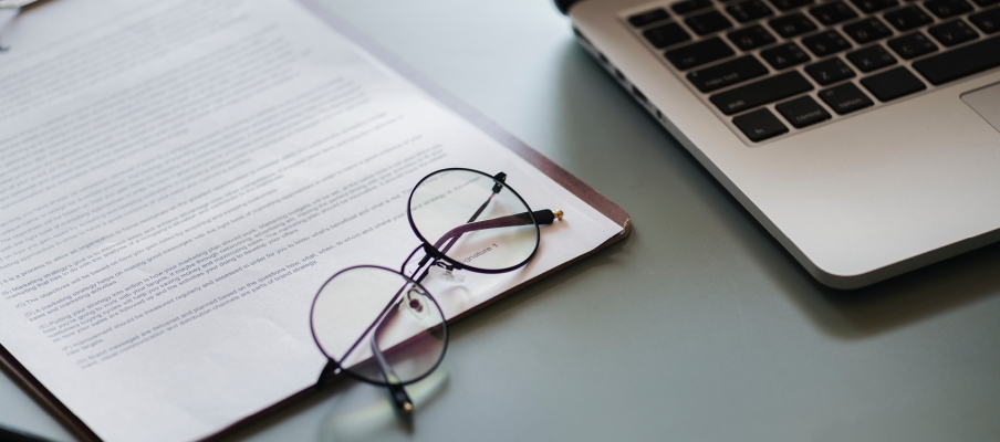 Glasses and a laptop on a desk